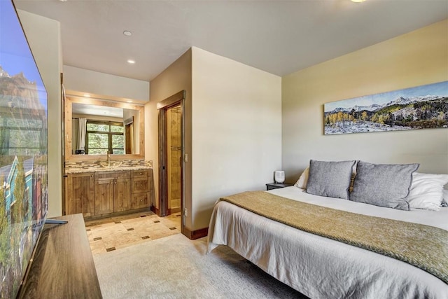 bedroom featuring recessed lighting, a sink, baseboards, light colored carpet, and ensuite bathroom