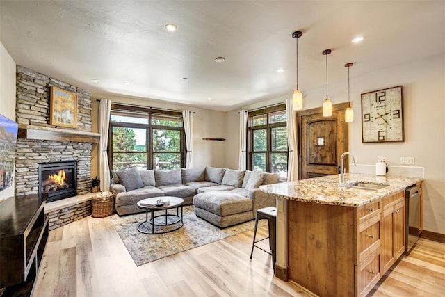 living area featuring light wood-type flooring, baseboards, and a fireplace