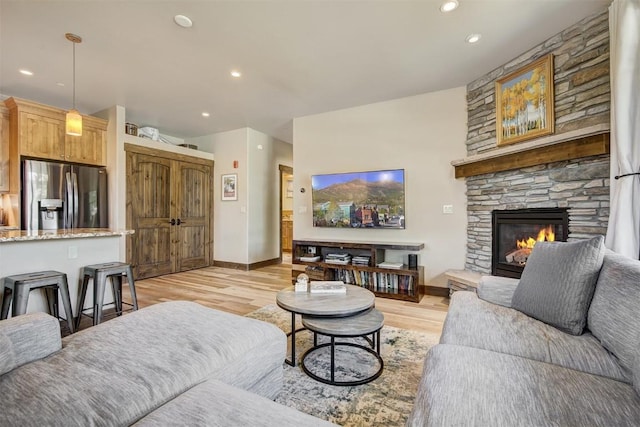 living room with recessed lighting, light wood-style floors, and baseboards