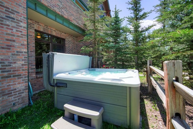 exterior space with a hot tub and fence