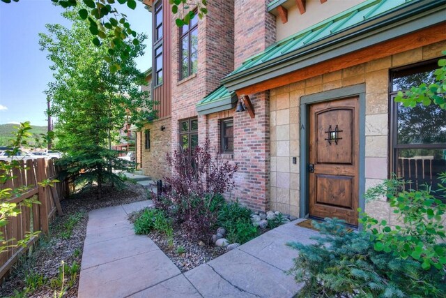 entrance to property with fence and brick siding