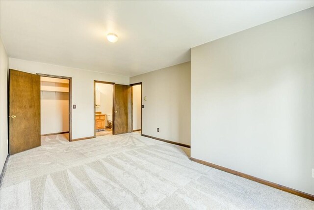 211 Burgundy Cir Unit Tract A, Silverthorne, CO 80498 - unfurnished bedroom featuring a closet, light carpet, baseboards, a walk in closet, and ensuite bath
