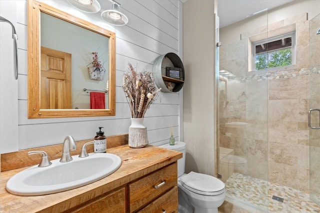 bathroom with vanity, a shower stall, and toilet