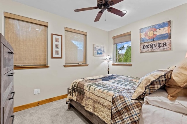 carpeted bedroom with a ceiling fan and baseboards