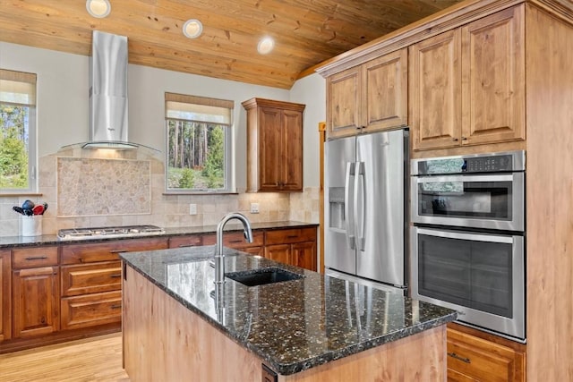 kitchen featuring a sink, appliances with stainless steel finishes, wall chimney exhaust hood, and a healthy amount of sunlight