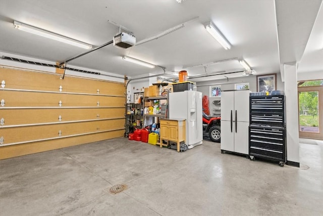 garage with white refrigerator with ice dispenser and a garage door opener