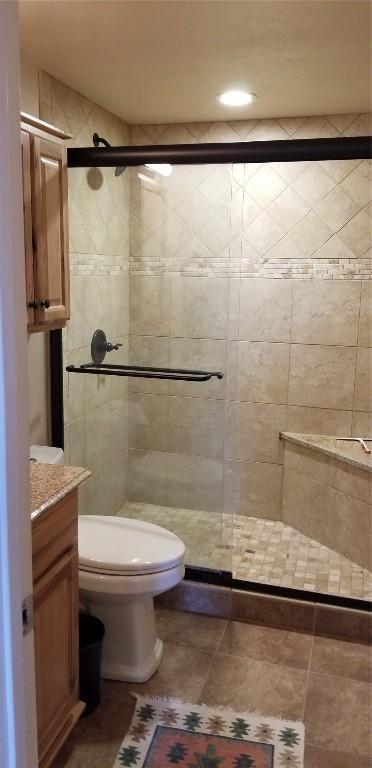 bathroom featuring vanity, recessed lighting, toilet, and a shower stall