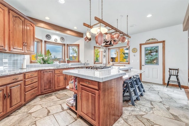 kitchen featuring a center island, sink, decorative backsplash, a notable chandelier, and beam ceiling