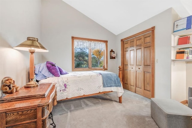 carpeted bedroom with a closet and vaulted ceiling