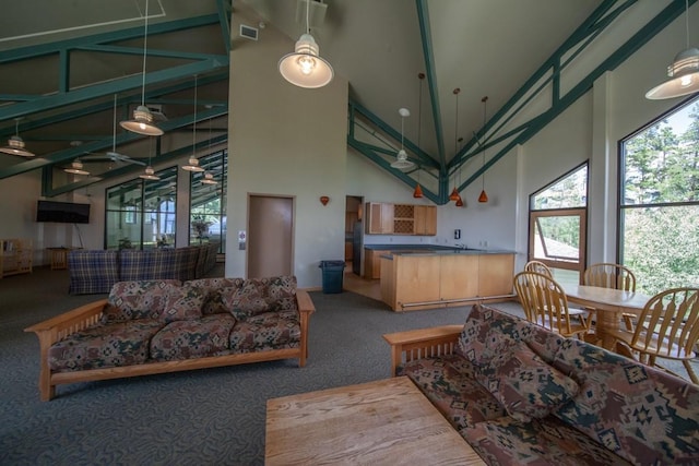 carpeted living room with high vaulted ceiling