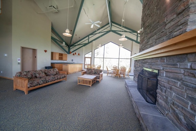 carpeted living room featuring beam ceiling, a stone fireplace, ceiling fan, and high vaulted ceiling