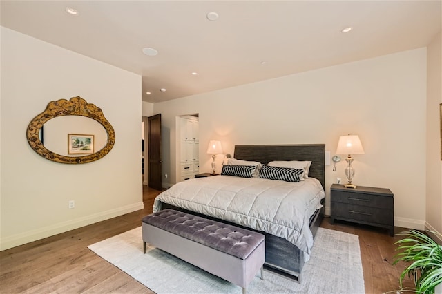 bedroom with baseboards, recessed lighting, and wood finished floors