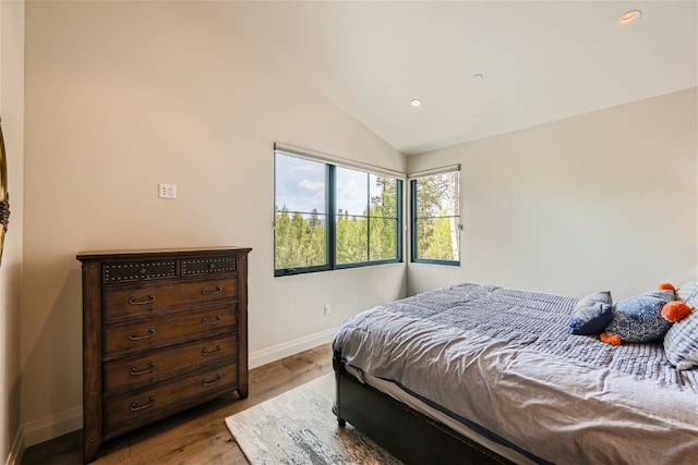 bedroom featuring baseboards, recessed lighting, wood finished floors, and lofted ceiling