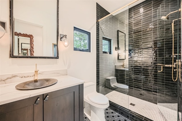 bathroom featuring toilet, a stall shower, and vanity