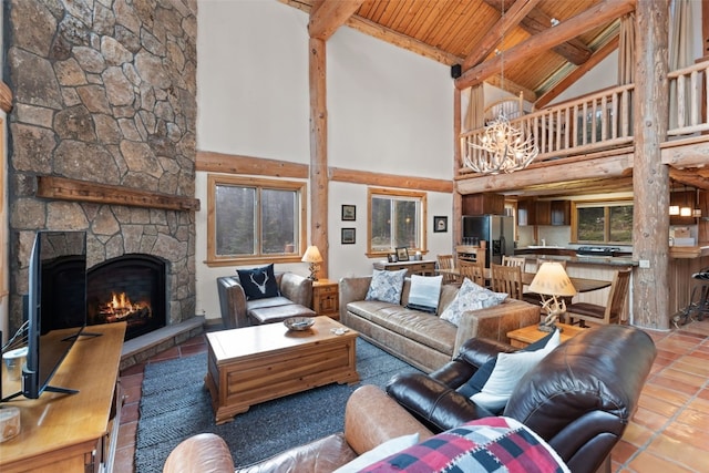 living room featuring beam ceiling, a chandelier, wooden ceiling, a stone fireplace, and high vaulted ceiling