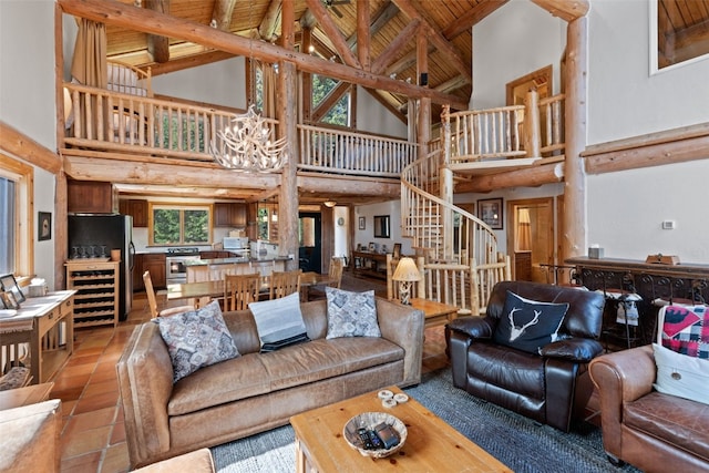 living room featuring high vaulted ceiling, stairs, beverage cooler, beamed ceiling, and a notable chandelier