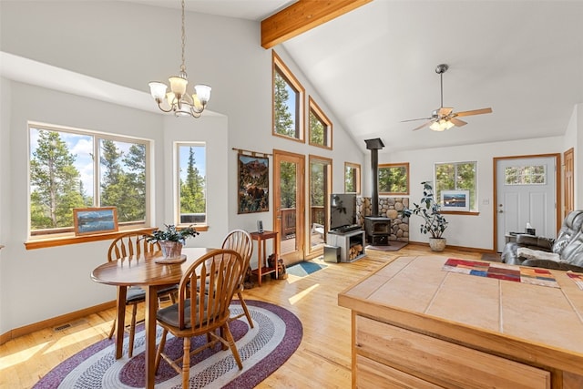 1576 Bobcat Ln, Fairplay, CO 80440 - dining area featuring a wood stove, beam ceiling, light wood-type flooring, high vaulted ceiling, and a chandelier