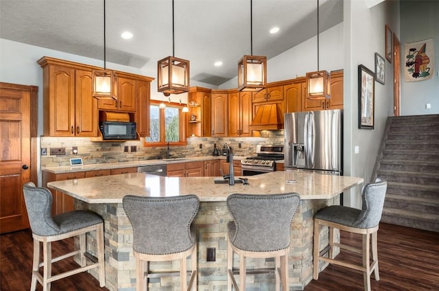 40870 Purple Sage St, Steamboat Springs, CO 80487 - kitchen featuring stainless steel appliances, decorative backsplash, a kitchen island with sink, a sink, and lofted ceiling