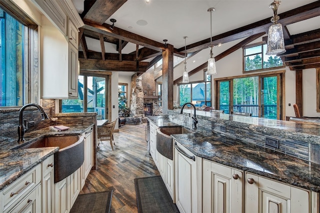 19 Peak 8 Ct, Breckenridge, CO 80424 - kitchen featuring dark wood finished floors, a fireplace, dark stone counters, open floor plan, and hanging light fixtures