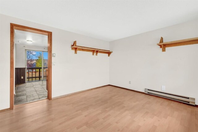 244 Harvest Dr Unit 244, Hayden, CO 81639 - empty room featuring a baseboard heating unit, light wood-type flooring, and baseboards