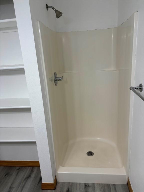 1550 Red Hawk Ct, Steamboat Springs, CO 80487 - bathroom featuring baseboards, wood finished floors, and a stall shower