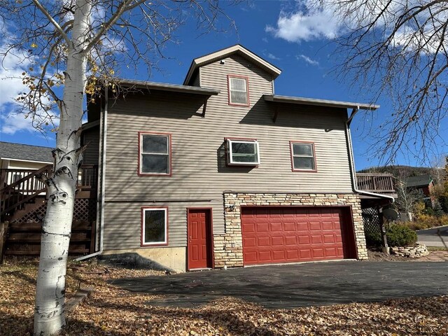 1550 Red Hawk Ct, Steamboat Springs, CO 80487 - view of front of house featuring a garage and aphalt driveway