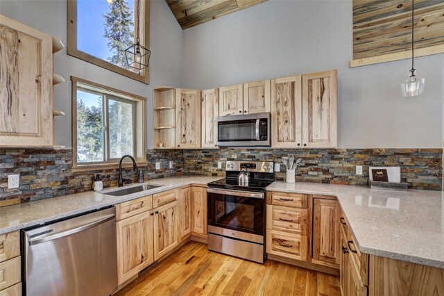 kitchen with appliances with stainless steel finishes, a sink, light brown cabinets, open shelves, and a high ceiling