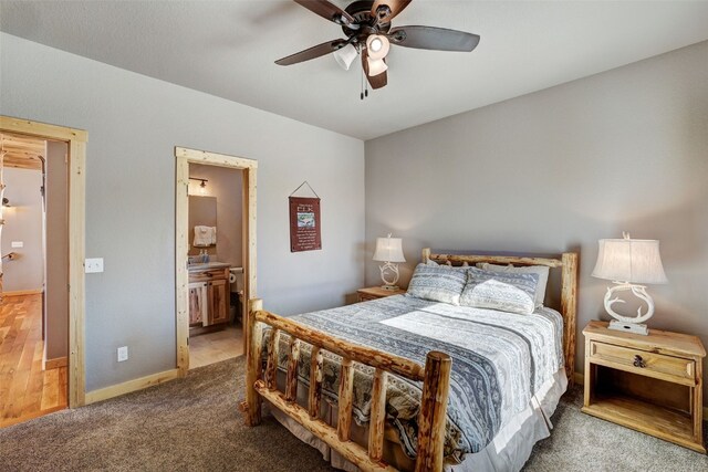 bedroom featuring carpet floors, ensuite bath, ceiling fan, and baseboards