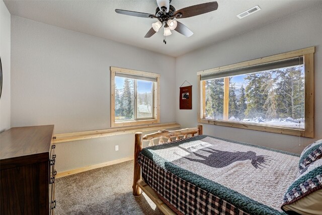 carpeted bedroom featuring baseboards and ceiling fan