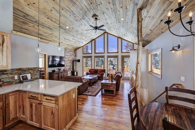 kitchen with wood finished floors, a ceiling fan, wooden ceiling, high vaulted ceiling, and hanging light fixtures