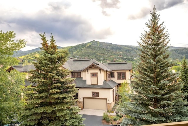 1463 Flattop Cir Unit 302, Steamboat Springs, CO 80487 - view of front of house featuring a mountain view, a garage, stucco siding, and stone siding