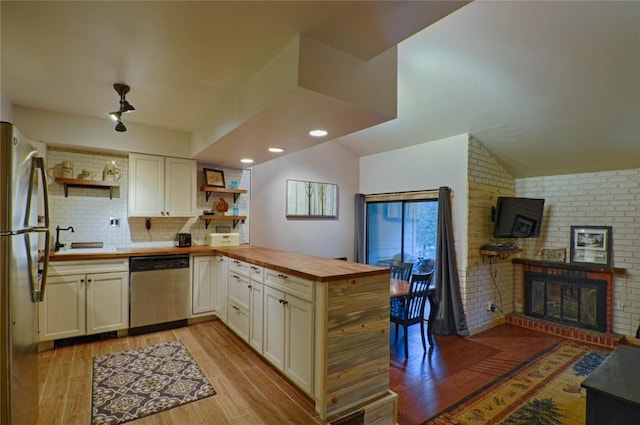 246 Broken Lance Dr Unit 203, Breckenridge, CO 80424 - kitchen featuring stainless steel appliances, open shelves, a peninsula, a sink, and butcher block countertops