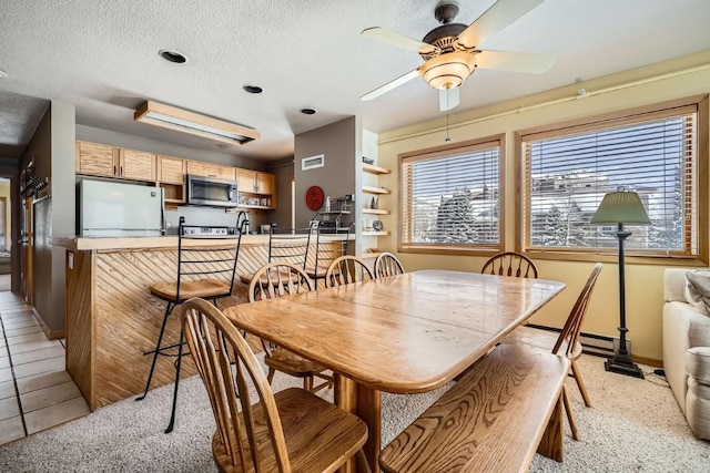 dining space with visible vents, baseboards, a baseboard radiator, a textured ceiling, and ceiling fan