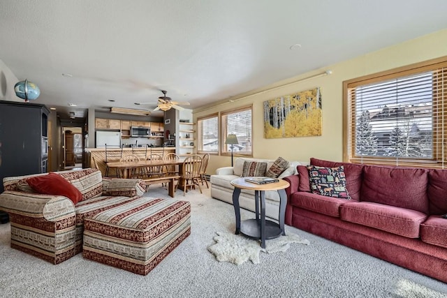 living area featuring carpet flooring and ceiling fan