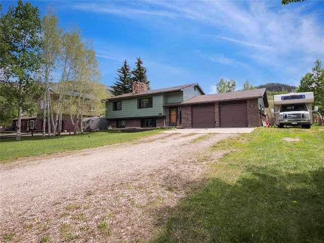 1346 Rainbow Dr, Silverthorne, CO 80498 - tri-level home with brick siding, a chimney, an attached garage, a front lawn, and driveway