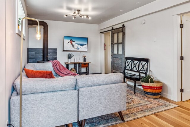 530 Castello Ave, Fairplay, CO 80440 - living area with a barn door, wood finished floors, a wood stove, and baseboards