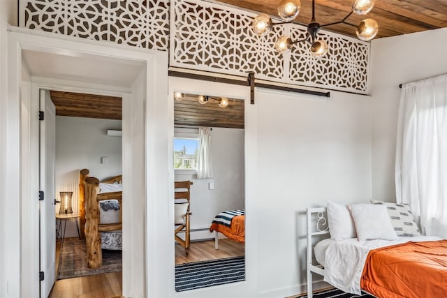 530 Castello Ave, Fairplay, CO 80440 - bedroom with a barn door, wood finished floors, wood ceiling, a baseboard heating unit, and baseboards