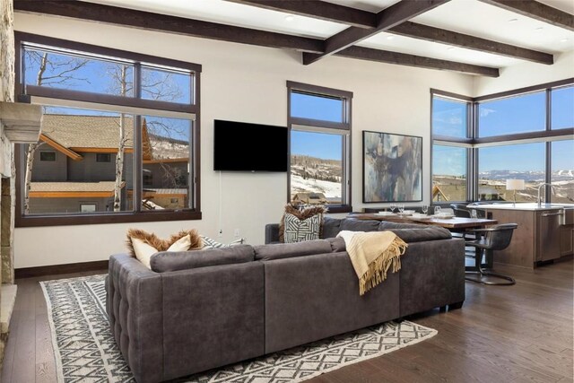 11 Glazer Trl, Silverthorne, CO 80498 - living room featuring dark wood-style floors, baseboards, beam ceiling, and a healthy amount of sunlight