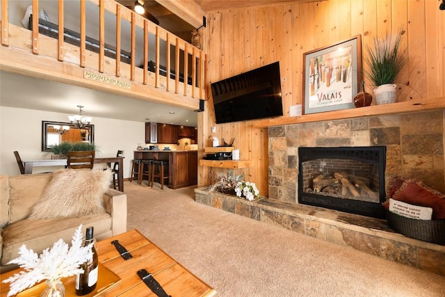 1945 Cornice Rd Unit 304 2334, Steamboat Springs, CO 80487 - living area with a notable chandelier, carpet, wood walls, a towering ceiling, and a fireplace