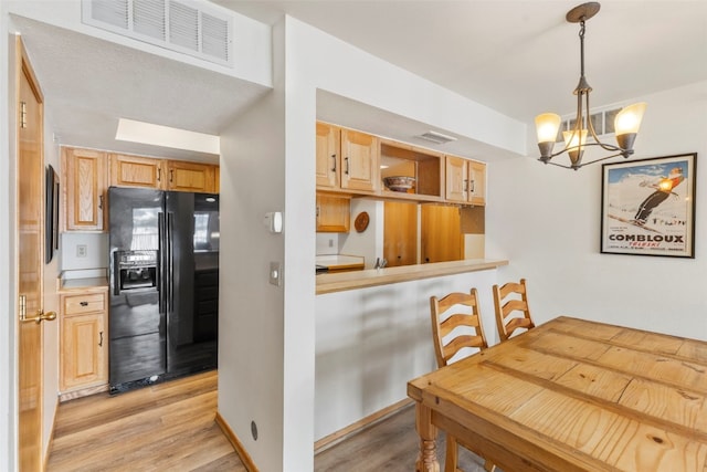 dining room with light wood finished floors, baseboards, visible vents, and a chandelier