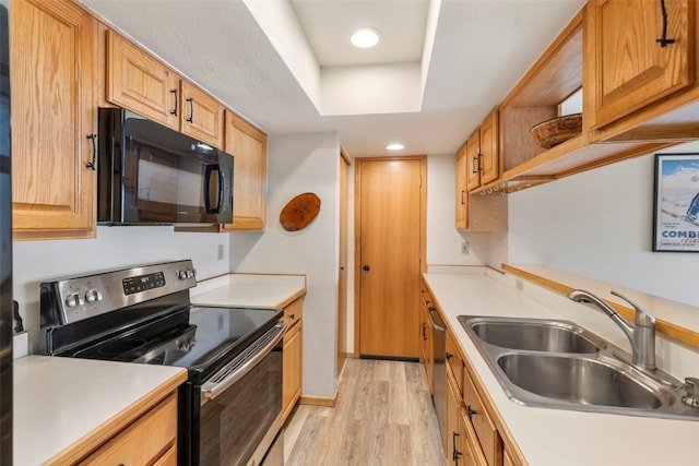 kitchen with a sink, light wood-style floors, stainless steel appliances, light countertops, and recessed lighting
