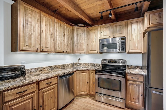 2300 Lodge Pole Cir Unit 105, Wildernest, CO 80498 - kitchen featuring appliances with stainless steel finishes, wood ceiling with exposed beams, light stone counters, track lighting, and light wood-style flooring