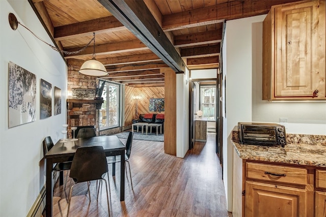 2300 Lodge Pole Cir Unit 105, Wildernest, CO 80498 - dining room with wood ceiling with exposed beams, wood finished floors, a baseboard heating unit, and wooden walls