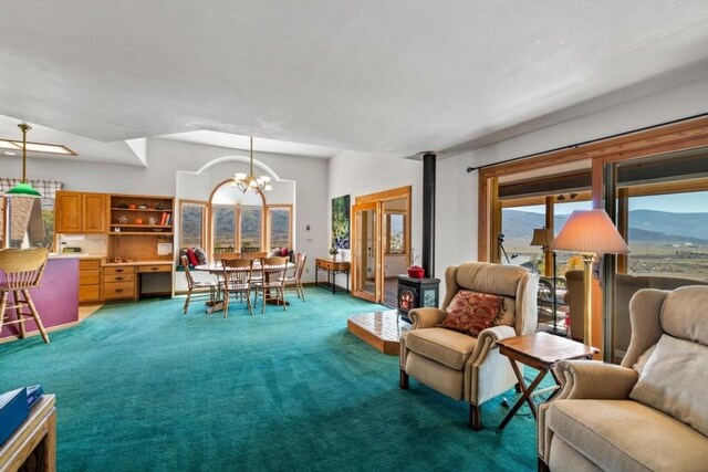 34995 Country Green Rd, Steamboat Springs, CO 80487 - living area featuring an inviting chandelier, a wood stove, and light carpet