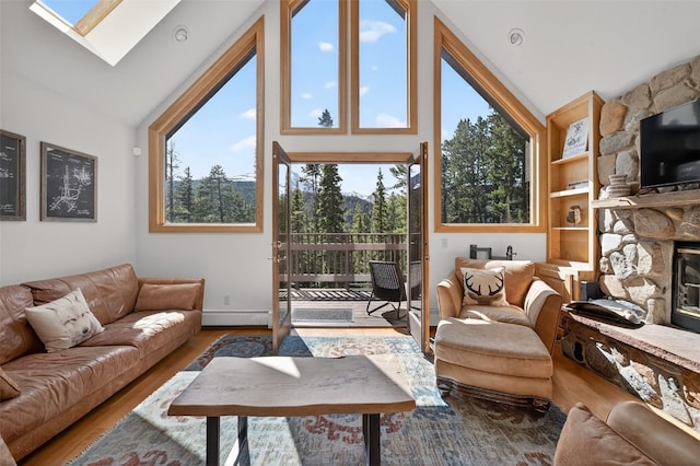 773 Range Rd, Breckenridge, CO 80424 - living room featuring healthy amount of natural light, a fireplace, high vaulted ceiling, wood finished floors, and a skylight