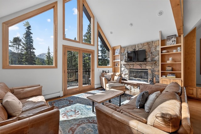 773 Range Rd, Breckenridge, CO 80424 - living area featuring a baseboard heating unit, built in shelves, a stone fireplace, wood finished floors, and baseboard heating