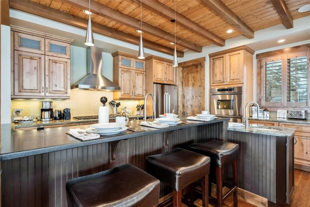 2542 Ski Trail Ln, Steamboat Springs, CO 80487 - kitchen featuring tasteful backsplash, stainless steel appliances, wooden ceiling, wall chimney exhaust hood, and a kitchen island with sink