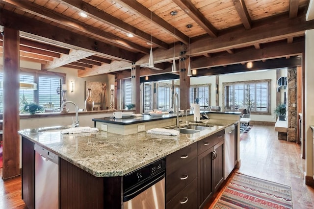 2542 Ski Trail Ln, Steamboat Springs, CO 80487 - kitchen featuring beam ceiling, a kitchen island with sink, dishwasher, and a sink