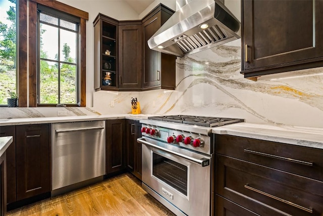 455 Highfield Trl, Breckenridge, CO 80424 - kitchen with wall chimney exhaust hood, stainless steel appliances, dark brown cabinets, healthy amount of natural light, and vaulted ceiling