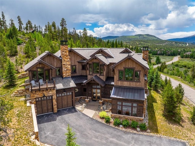 455 Highfield Trl, Breckenridge, CO 80424 - view of front of house featuring a chimney, stone siding, asphalt driveway, a garage, and a standing seam roof